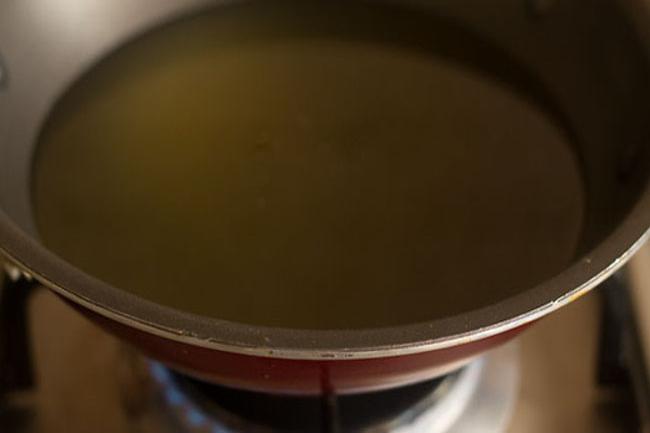 heating oil in a pan to fry besan sev. 