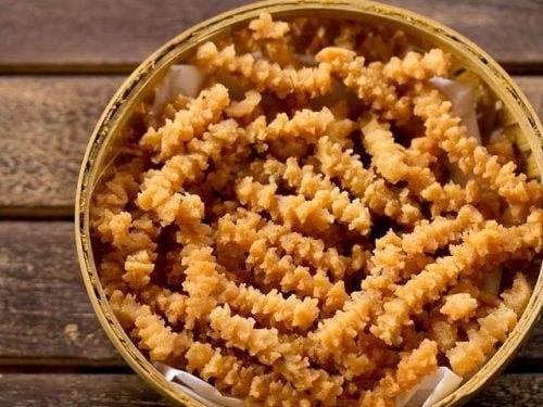 butter murukku served in a cane bowl with text layovers.