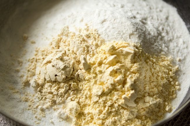rice flour, roasted chana dal flour and gram flour added in a bowl for making dough of butter chakli.
