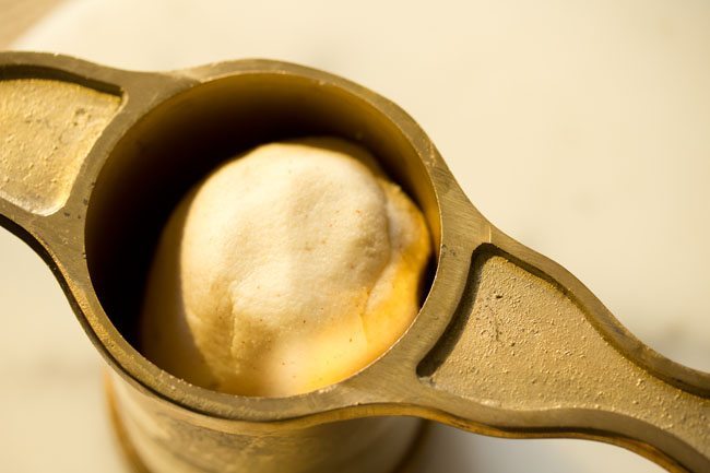 portion of dough placed inside the murukku maker. 