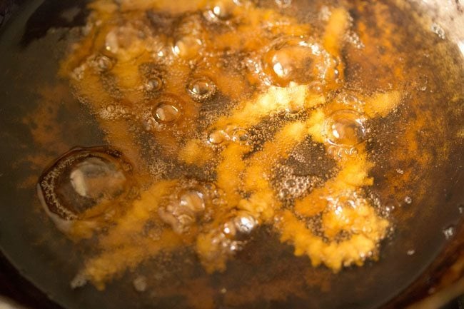frying butter murukku in hot oil till evenly golden.
