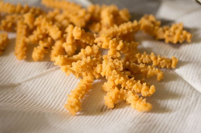 draining butter murukku on kitchen paper towels. 