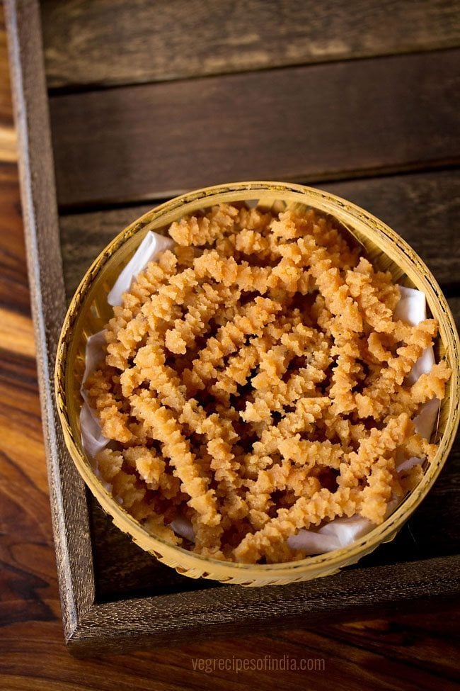 butter murukku served in a cane bowl with text layover. 