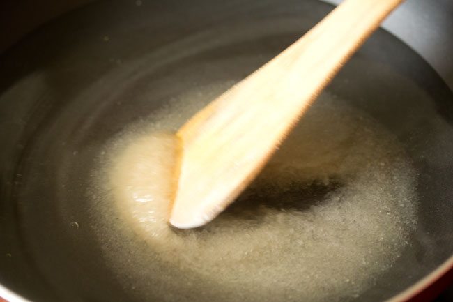 stirring sugar in water in pan. 