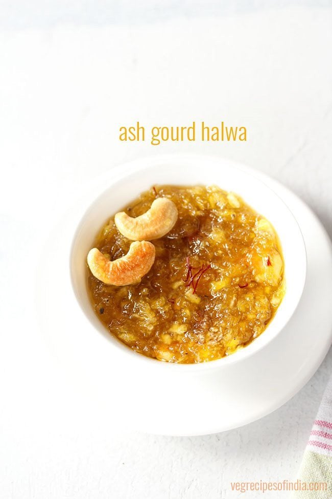 kashi halwa garnished with fried cashews served in a white bowl on a white plate with text layovers.