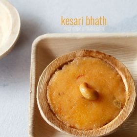 kesari bath garnished with a fried cashew and served in a bamboo bowl with text layover.