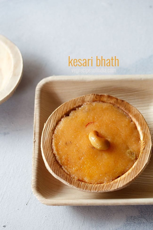 kesari bath garnished with a fried cashew and served in a bamboo bowl with text layover.