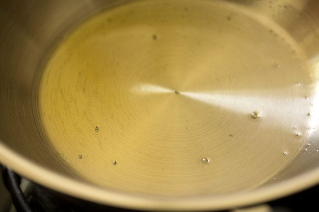 heating ghee in the pan for frying cashews for kesari bath recipe. 