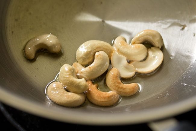 frying cashews in hot ghee till golden for kesari bath recipe. 