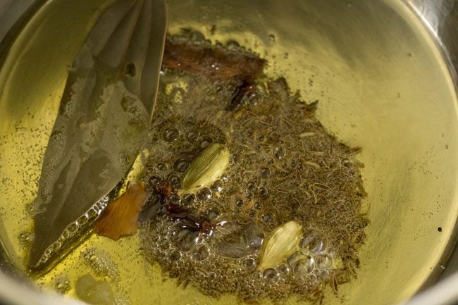 spices added to the hot ghee in pan. 