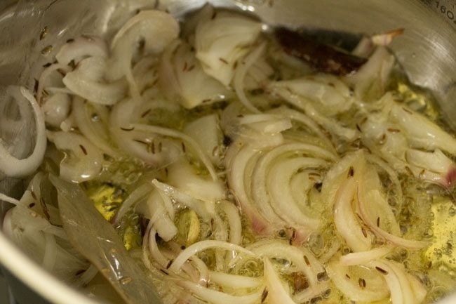 thinly sliced onions added to hot ghee in the pan. 