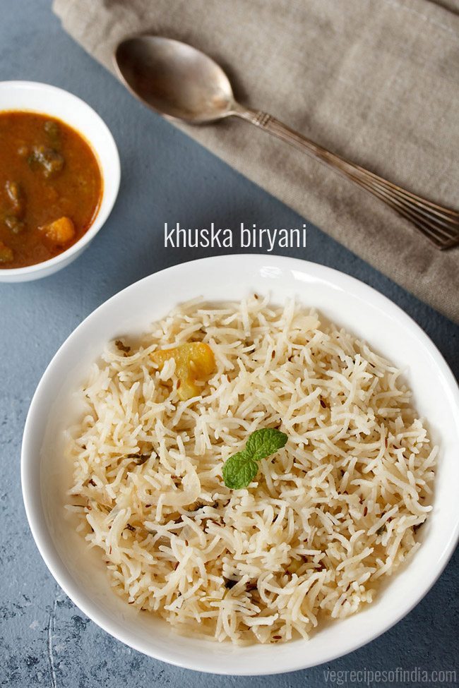 kuska rice garnished with a mint sprig and served in a white plate with a bowl of curry on the top left side, a spoon on the top right side and text layovers. 