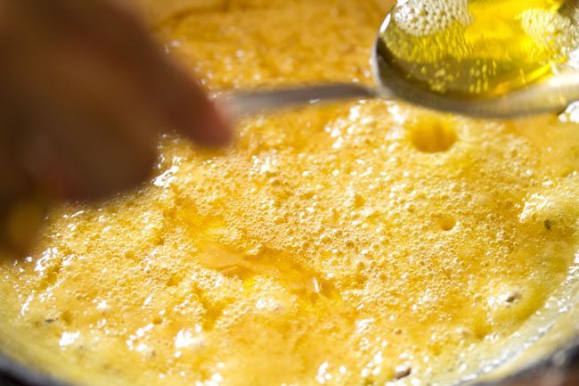 ghee being added to besan mixture