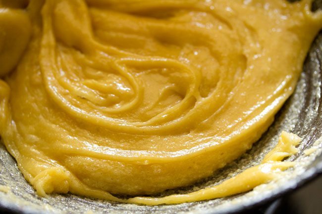 mysore pak batter being stirred and cooked to make it into fudge