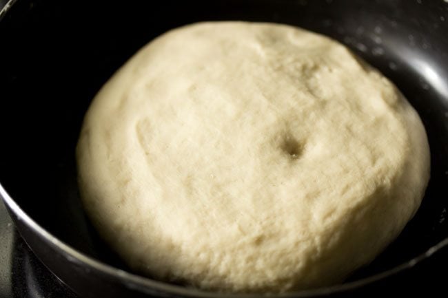 kneaded pizza dough after leavening in black bowl