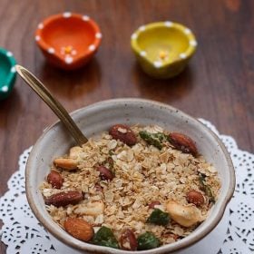 oats chivda served in a ceramic bowl with a spoon in it.