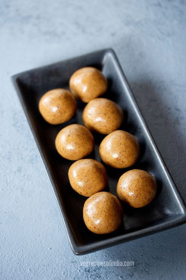 sattu ke laddu served on a black rectangular platter with text layover. 