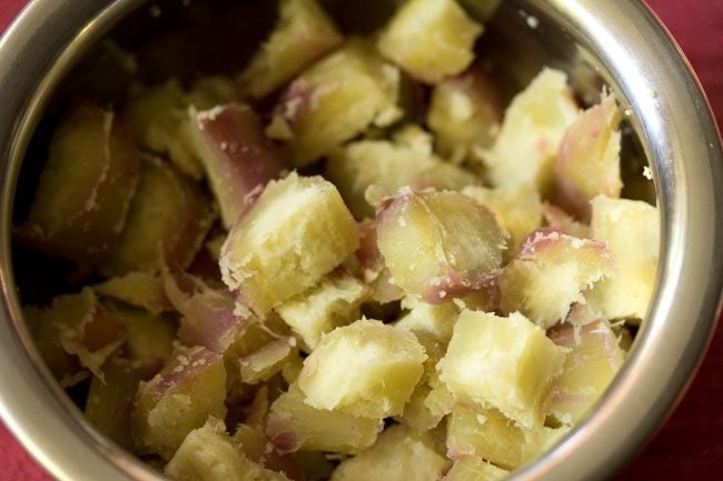 peeled and chopped steamed sweet potatoes added in a bowl for making shakarkandi chaat. 