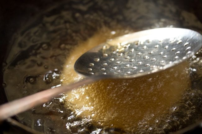 nudging with a slotted spoon to puff up the kachori while frying. 