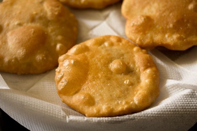 fried kachoris placed on kitchen paper towels. 