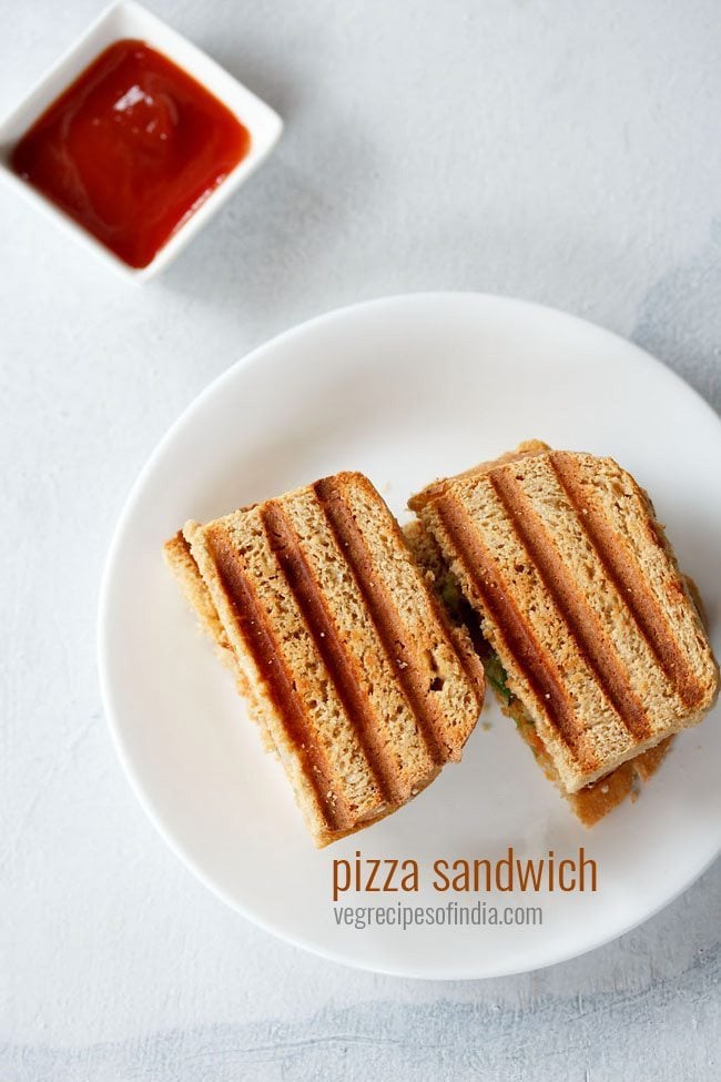 pizza sandwich served in a white place with tomato ketchup