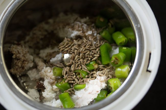 grated fresh coconut, chopped green chilies, cumin seeds and water added to a grinder jar. 