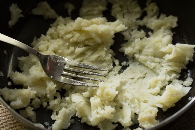 mashing potatoes with a fork.