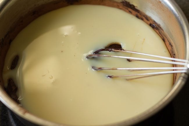 adding condensed milk to melted chocolate 