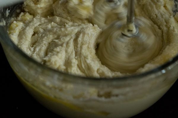 making cheesecake filling by using a hand mixer to beat the ingredients