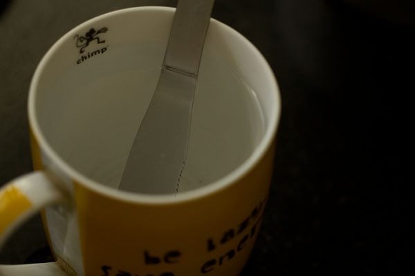butter knife in a mug of hot water