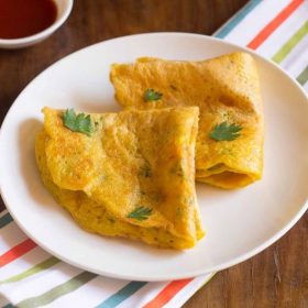 folded moong dal chilla on a white plate.