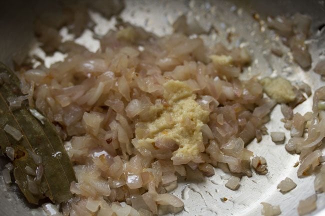 ginger garlic paste on top of sautéed onions in pan