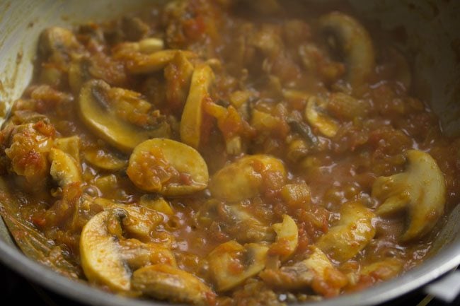 mushrooms in a bubbling gravy in pan