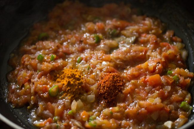 adding spices to the sauteed tomato