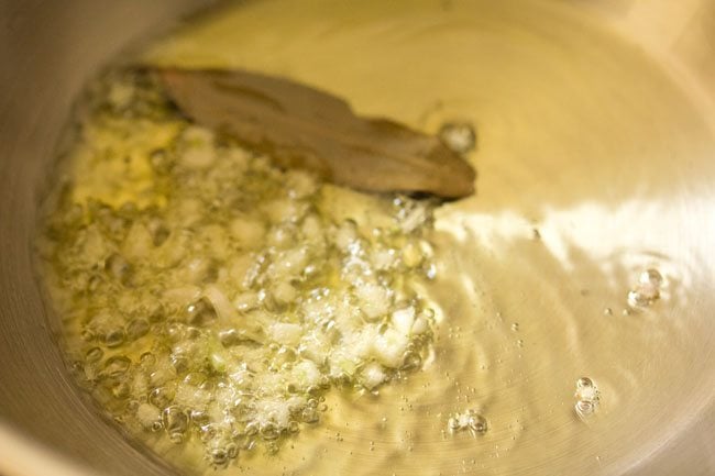 sautéing finely chopped garlic and bay leaf in hot olive oil on a pan. 