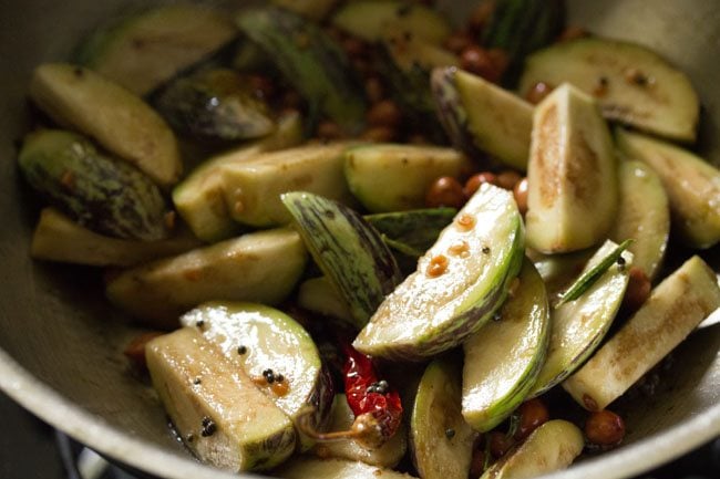 mixing brinjal pieces with the rest of the ingredients. 