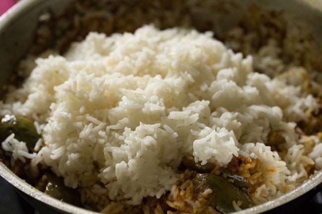 adding cooked rice to the brinjal masala. 