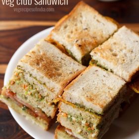 club sandwiches squares with layers seen on a white plate with tomato ketchup