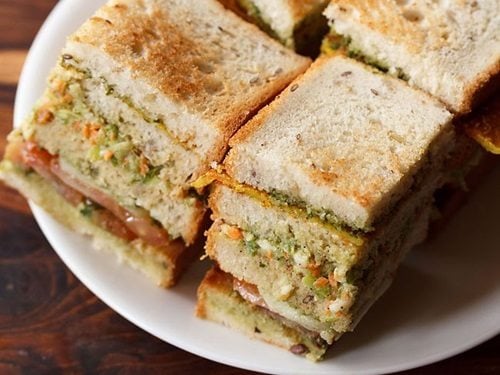 club sandwiches squares with layers seen on a white plate.