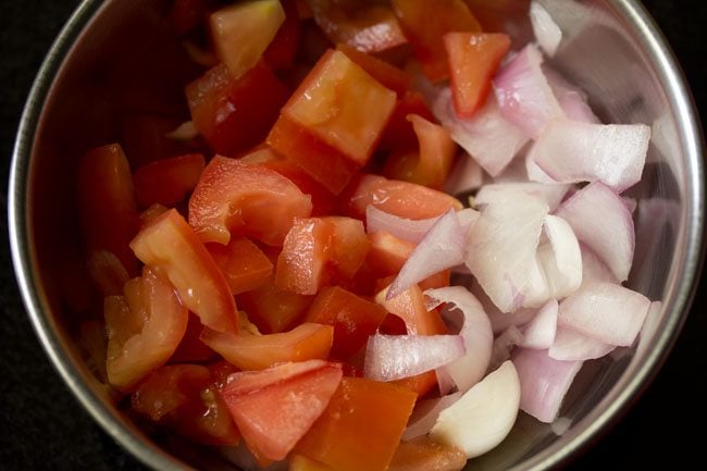 chopping onion, red bell pepper and tomato for topping of tawa pizza 