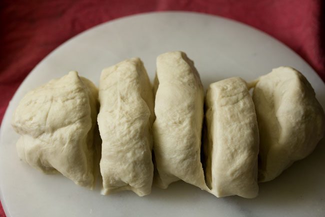 dividing the prepared pizza dough into equal parts