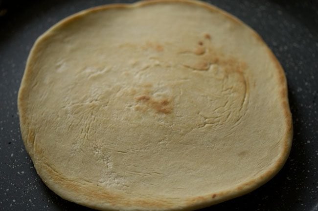 flip the prepared pizza base when browned and cook