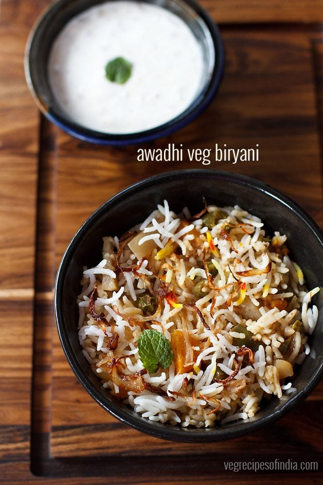 Lucknowi biryani served in a bowl with a side of raita