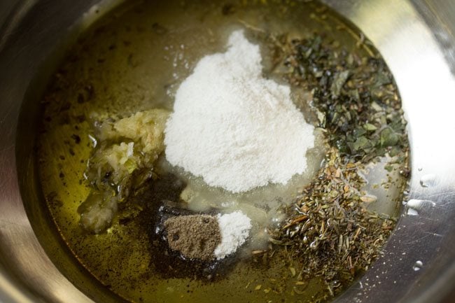 black pepper powder, oregano, basil, thyme, garlic, salt, rice flour and oil in a bowl