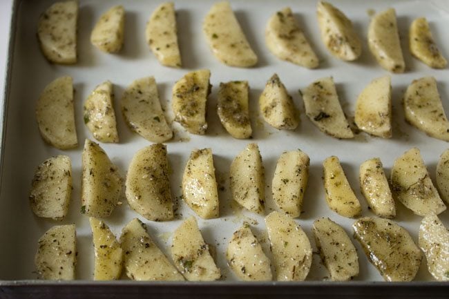 potatoes wedges lined on parchment paper 