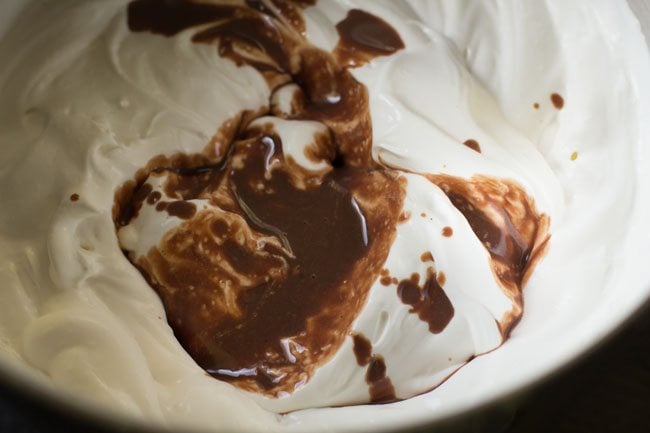 adding chocolate mixture to whipped cream 