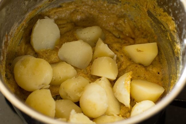 adding potatoes to make dum aloo recipe