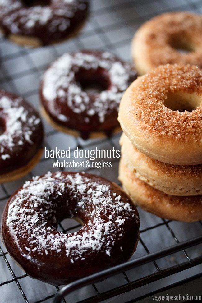 chocolate donut with more glazed donuts on wired rack.