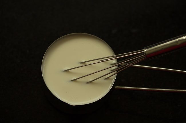 whisking the curd in a bowl