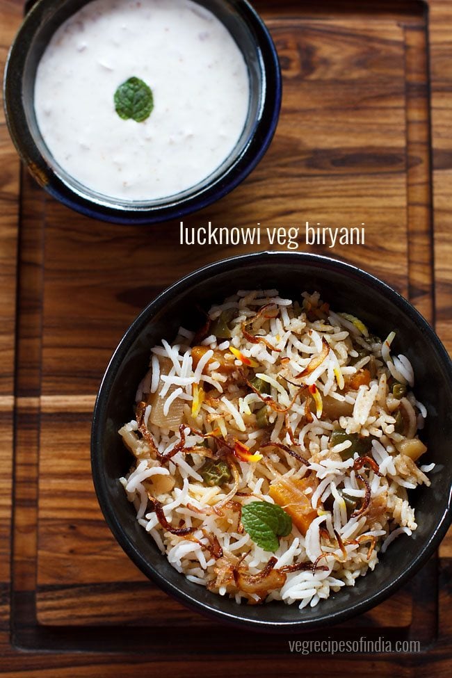 Lucknowi biryani served in a bowl with a side of raita